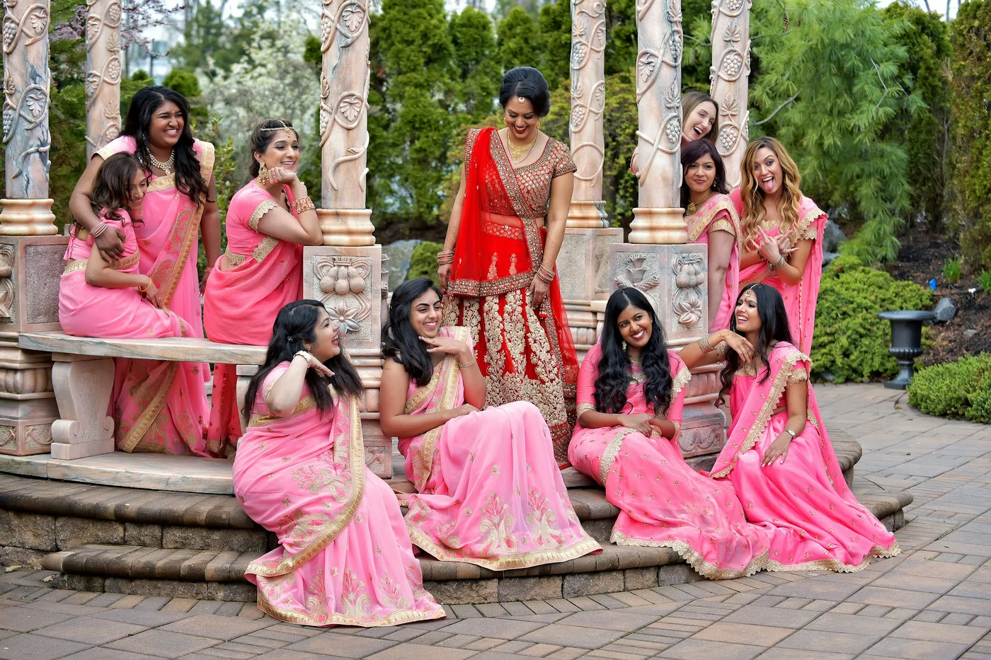 Bridal party in red and gold sarees ready for wedding functions